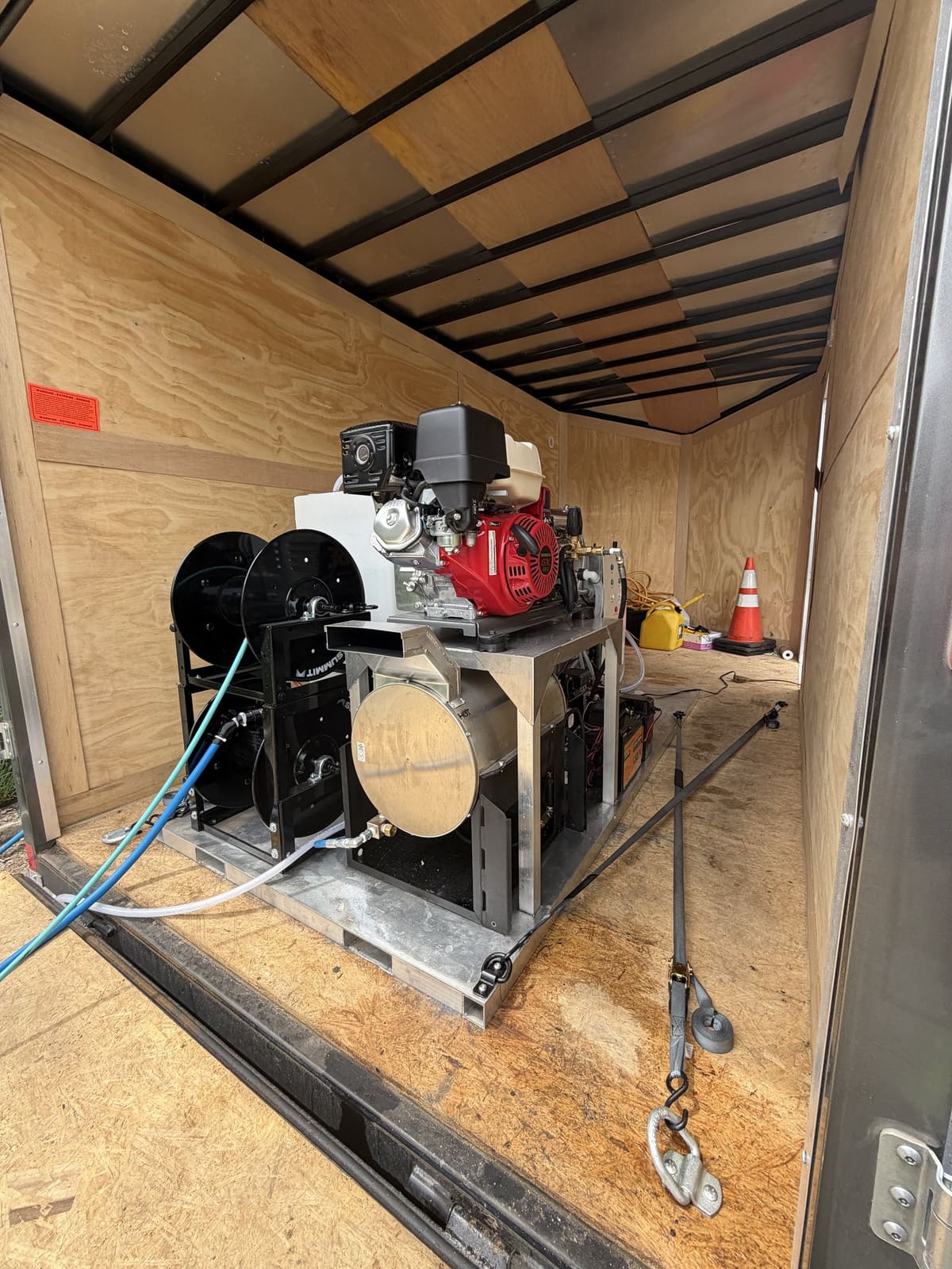 Le système WINDOSMART dans sa remorque : une pompe entraînée par moteur, des dévidoirs de boyau superposés et un cylindre en inox sur une seule plateforme.