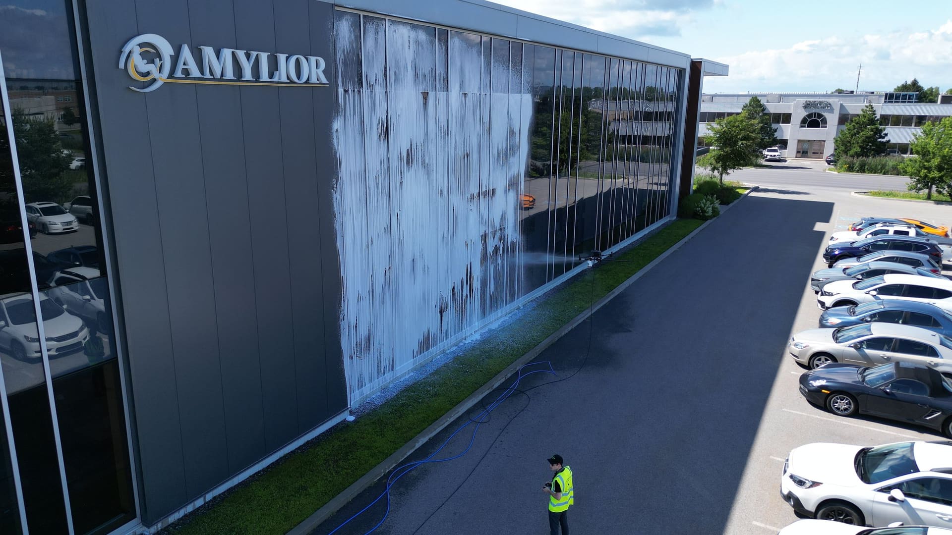 A band of soap on a glass office building, with the operator on the lot below.